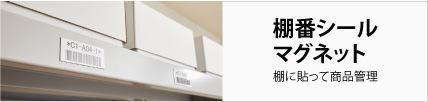 文字列とバーコードを印刷したマグネットが棚に貼られているところ 棚の上には白い箱が3つ並んでいる